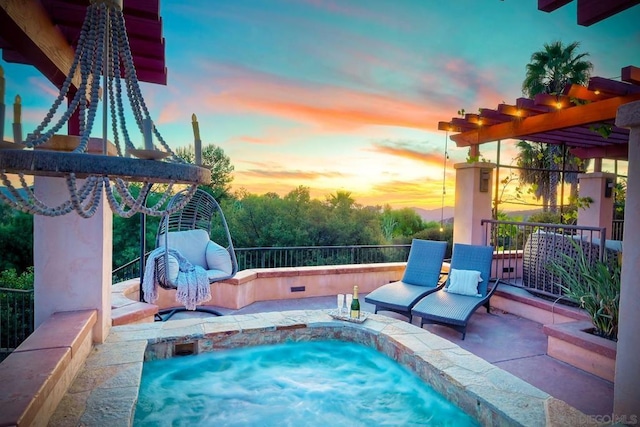 pool at dusk featuring a hot tub and a patio