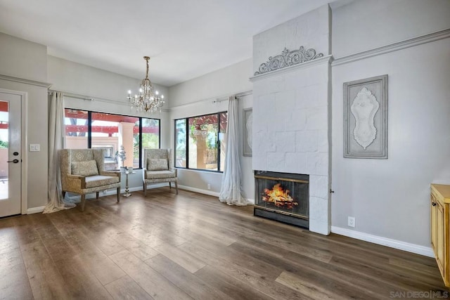 unfurnished room with dark hardwood / wood-style floors, a fireplace, and a notable chandelier