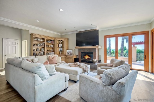 living room with light wood-type flooring, a fireplace, and crown molding