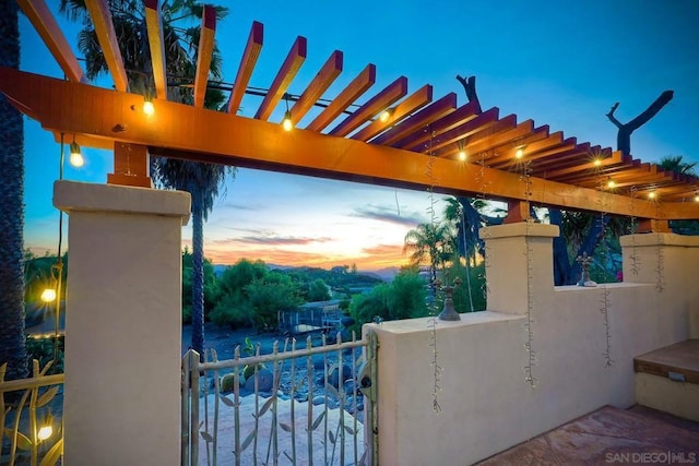 patio terrace at dusk featuring a pergola