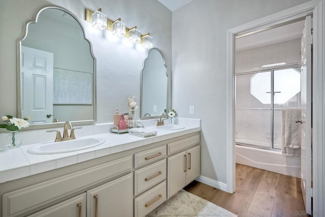 bathroom with bath / shower combo with glass door, vanity, and hardwood / wood-style floors