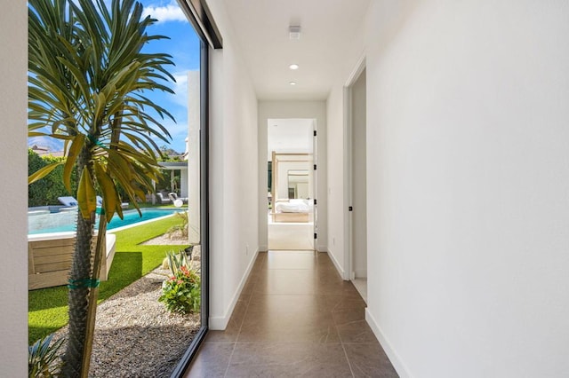 corridor featuring plenty of natural light and tile patterned flooring