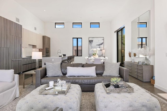 living room featuring a towering ceiling and concrete flooring