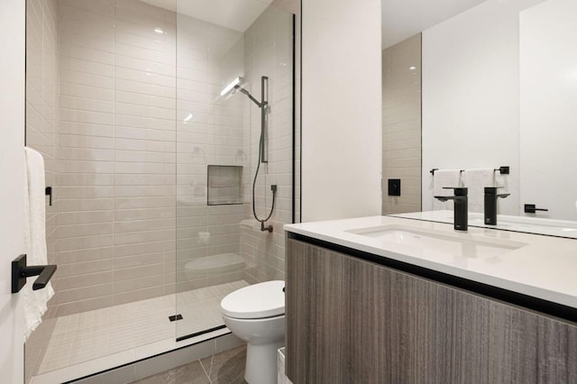 bathroom with toilet, tile patterned flooring, a tile shower, and vanity