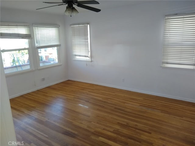 unfurnished room with ceiling fan and dark hardwood / wood-style floors