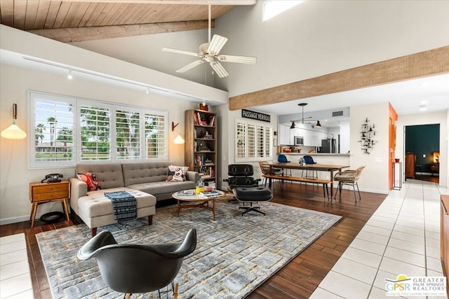 living room featuring ceiling fan, lofted ceiling with beams, wood ceiling, and hardwood / wood-style floors