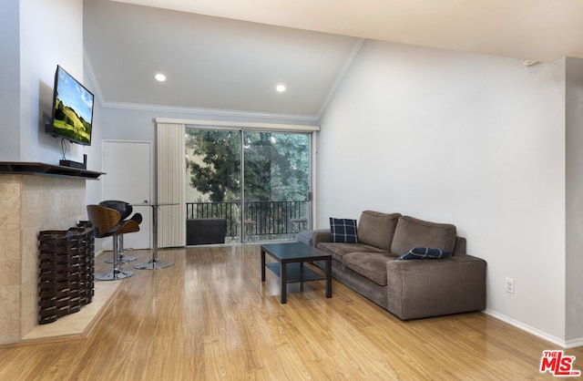 living room featuring vaulted ceiling, crown molding, and light wood-type flooring