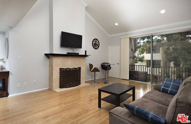 living room with lofted ceiling, crown molding, and light hardwood / wood-style flooring