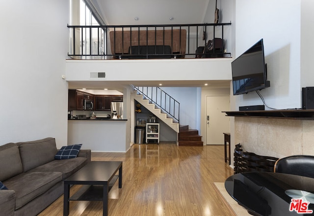 living room with a high ceiling and hardwood / wood-style floors