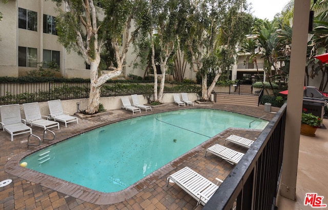 view of swimming pool with area for grilling and a patio