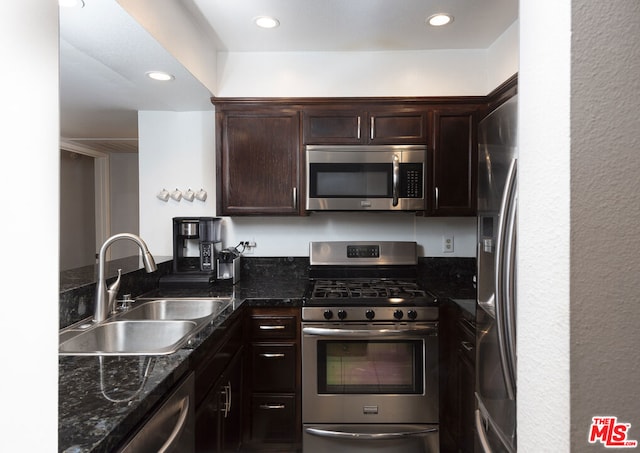 kitchen with dark stone countertops, sink, dark brown cabinets, and stainless steel appliances