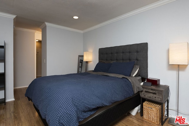 bedroom featuring crown molding and dark hardwood / wood-style floors