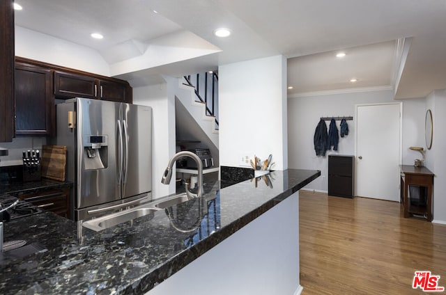 kitchen with dark brown cabinets, sink, stainless steel fridge, and kitchen peninsula