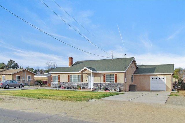 ranch-style house with central air condition unit and a garage