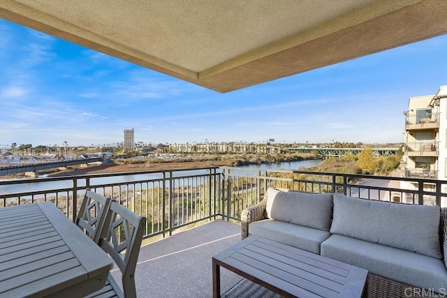 balcony featuring outdoor lounge area and a water view