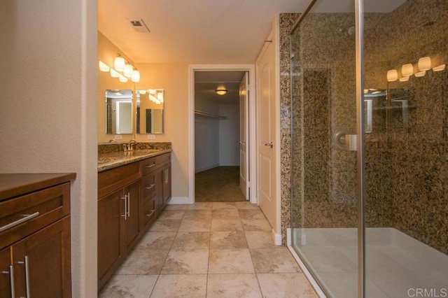 bathroom with an enclosed shower, vanity, and tile patterned floors