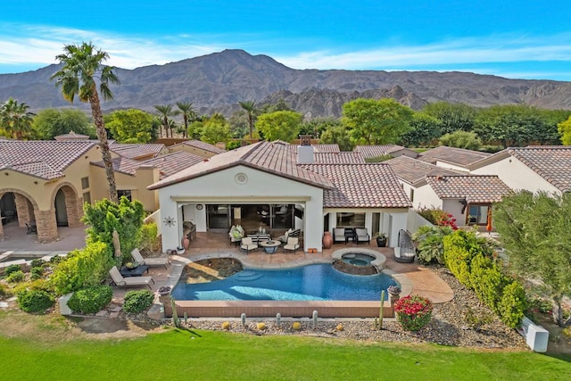 rear view of property featuring an outdoor hangout area, a pool with hot tub, a patio area, and a mountain view