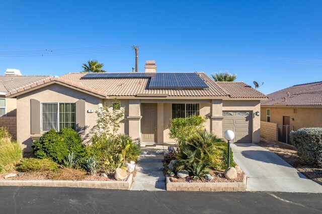 view of front of house with a garage and solar panels