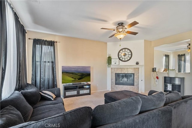 carpeted living room with ceiling fan and a fireplace