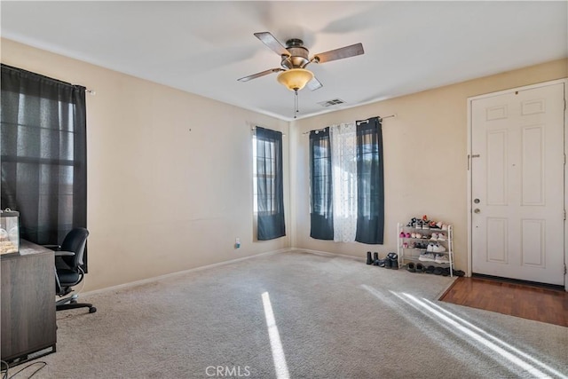 interior space with ceiling fan and light colored carpet