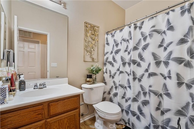 bathroom featuring toilet, vanity, and a shower with shower curtain