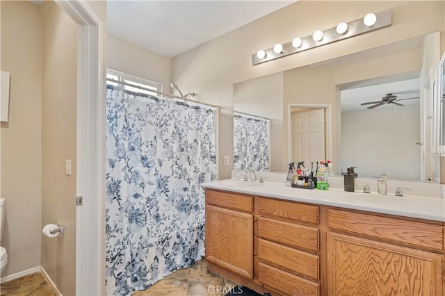 bathroom with toilet, ceiling fan, vanity, and curtained shower