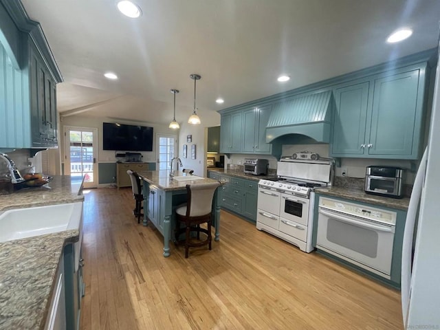 kitchen with premium range hood, sink, hanging light fixtures, light hardwood / wood-style flooring, and white appliances