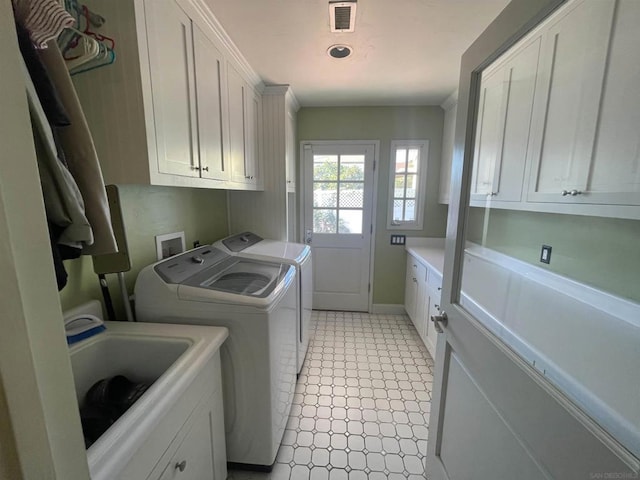 laundry area featuring separate washer and dryer, sink, and cabinets