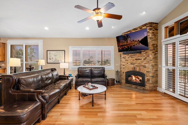 living room with a fireplace, light hardwood / wood-style floors, plenty of natural light, and ceiling fan