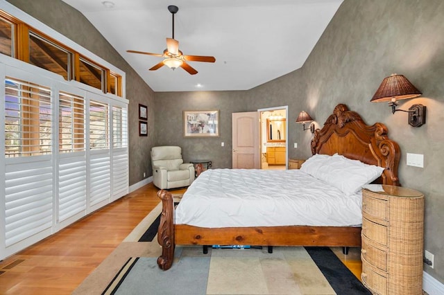 bedroom featuring ceiling fan, light hardwood / wood-style floors, connected bathroom, and lofted ceiling