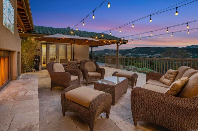 patio terrace at dusk with a mountain view and an outdoor hangout area