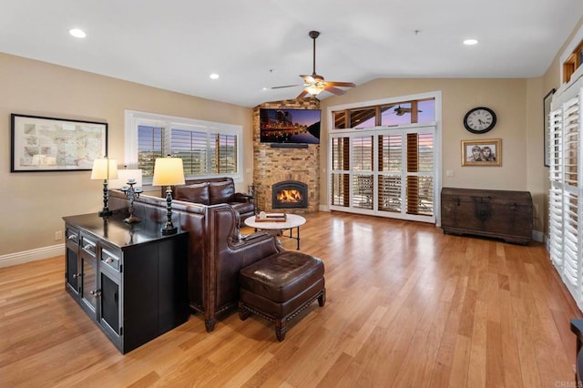 living room with ceiling fan, lofted ceiling, and light hardwood / wood-style flooring