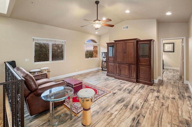 living room with ceiling fan, light hardwood / wood-style flooring, and lofted ceiling