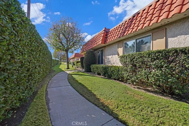 view of side of home with a lawn