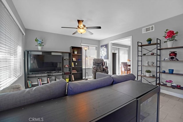 tiled living room featuring ceiling fan