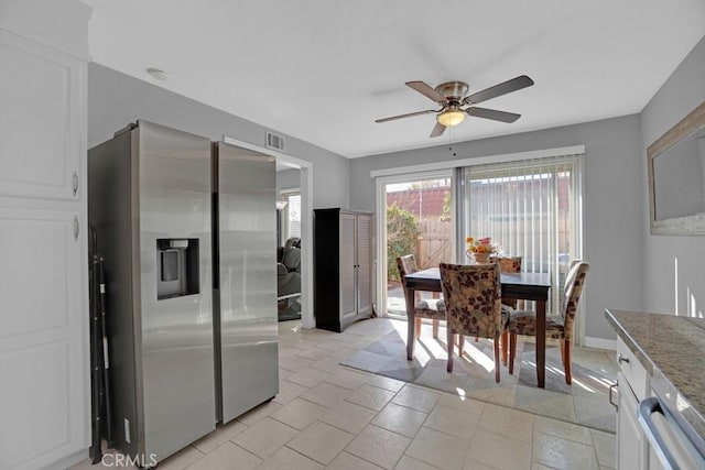 interior space featuring stainless steel fridge with ice dispenser, ceiling fan, light tile patterned flooring, and white cabinets