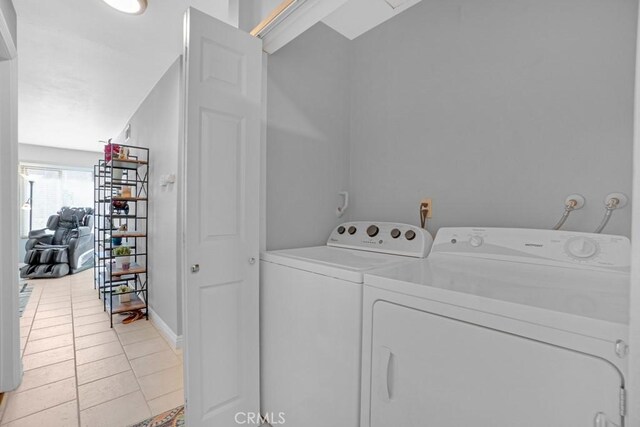 washroom with light tile patterned flooring and washer and clothes dryer