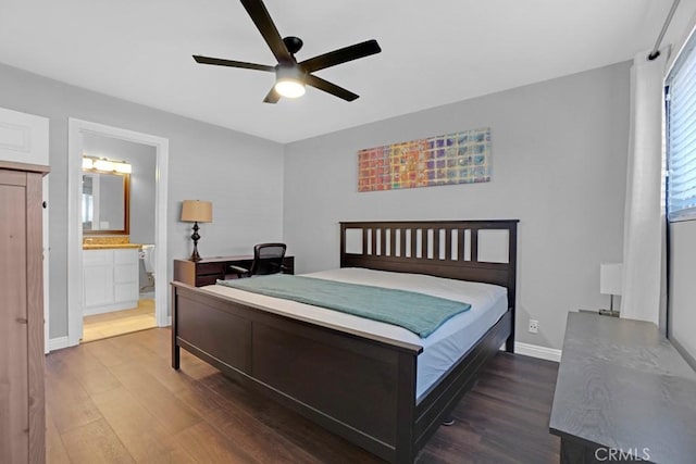 bedroom featuring ceiling fan, dark wood-type flooring, and ensuite bath