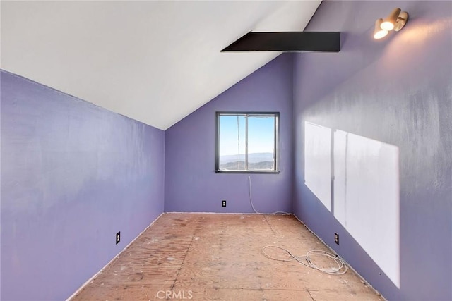 additional living space featuring vaulted ceiling with beams