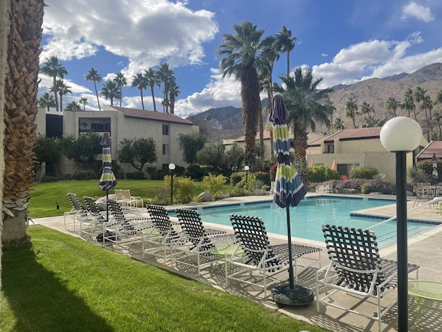 view of pool with a mountain view, a yard, and a patio area