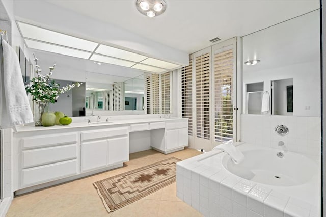 bathroom featuring tiled bath, tile patterned flooring, and vanity