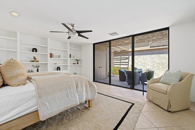 bedroom featuring access to outside, a wall of windows, ceiling fan, and light tile patterned flooring