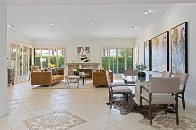 dining space with a fireplace, light tile patterned floors, plenty of natural light, and ornamental molding