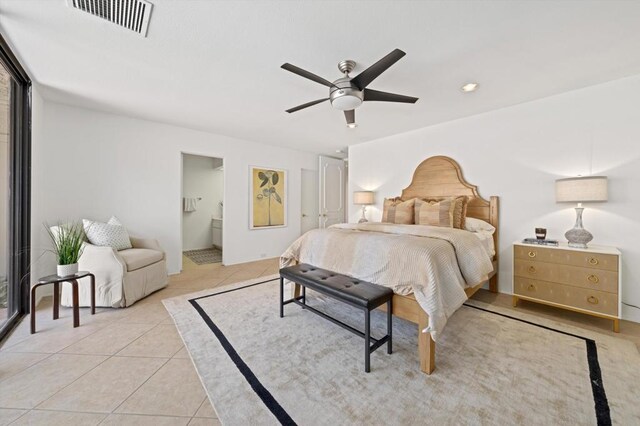 bedroom featuring ceiling fan, light tile patterned floors, and ensuite bath