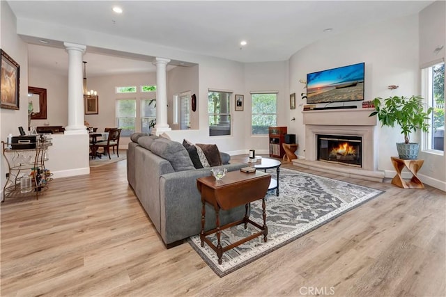 living room with a healthy amount of sunlight, a notable chandelier, and light hardwood / wood-style floors