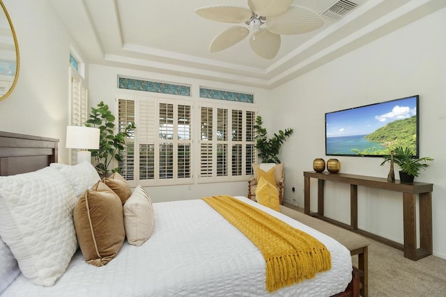 bedroom featuring ceiling fan, carpet, and a tray ceiling