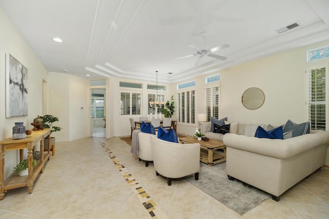 living room featuring ceiling fan, a raised ceiling, and light tile patterned flooring