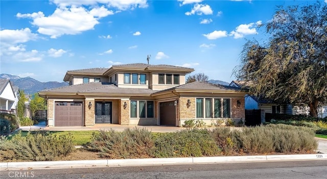 prairie-style home with a mountain view and a garage