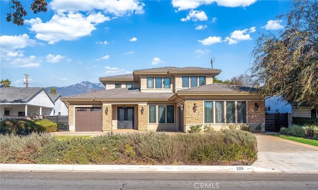 prairie-style home featuring a garage and a mountain view