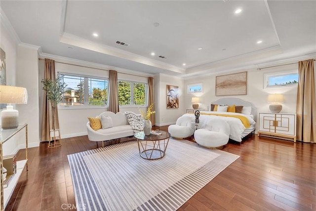 bedroom with crown molding, dark hardwood / wood-style floors, and a tray ceiling